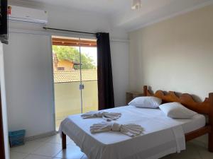 a bedroom with a bed with a bow tie on it at Pousada Werneck Residence Suites in Ubatuba