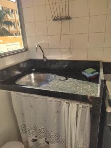 a bathroom counter with a sink and a shower at Claudia Apartment in Vila Velha