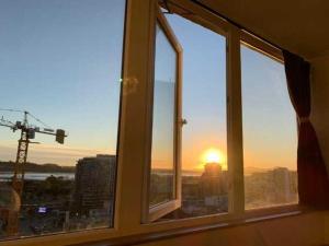 uma janela com vista para o pôr-do-sol numa cidade em Departamento 1 ambiente amoblado hermosa vista Chacabuco esquina salas em Concepción