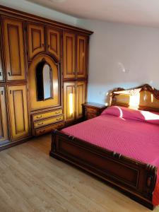 Schlafzimmer mit einem Bett mit einer roten Decke und einem Spiegel in der Unterkunft Attico Mansardato in San Salvo