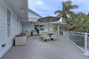 a deck with a table and chairs and an umbrella at Surrounded By Sea Breezes - Anna Maria, FL in Anna Maria