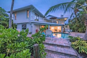 a home with a swimming pool and a house at Surrounded By Sea Breezes - Anna Maria, FL in Anna Maria