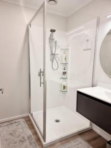 a white bathroom with a shower and a sink at Cosy homestay in Upper Hutt in Upper Hutt