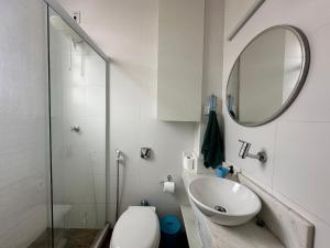 uma casa de banho com um WC, um lavatório e um espelho. em Bela vista no Leblon - a 2 quadras da praia no Rio de Janeiro