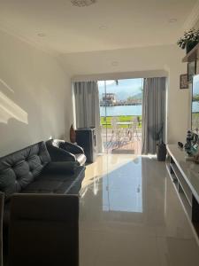 a living room with a couch and a view of the ocean at Lindo apartamento em angra dos reis in Angra dos Reis