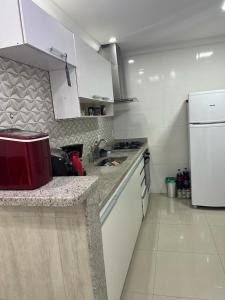 a kitchen with a sink and a white refrigerator at Lindo apartamento em angra dos reis in Angra dos Reis