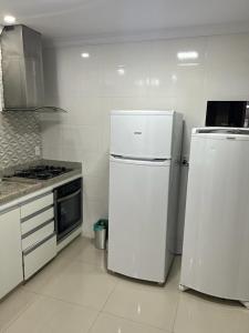 a kitchen with two white refrigerators and a stove at Lindo apartamento em angra dos reis in Angra dos Reis