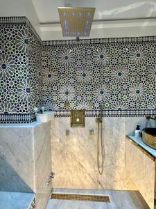 een badkamer met zwarte en witte tegels op de muur bij Wilaya Sunset Luxe, Private Jacuzzi & Hamam, Tetuan in Tetouan