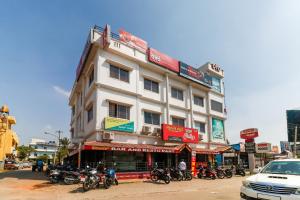 a white building with motorcycles parked in front of it at Super OYO 40825 Jeevan Residency in Mysore