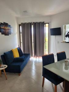 a living room with a blue couch and a table at Apartamento com varanda Reserva do Sahy in Mangaratiba