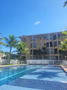 a large swimming pool in front of a building at Apartamento com varanda Reserva do Sahy in Mangaratiba