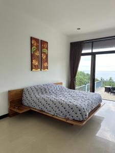 a bedroom with a bed and a large window at Luxurious Pool villa with great sea view in Ko Phangan