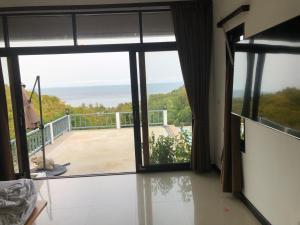 a room with a large glass door to a balcony at Luxurious Pool villa with great sea view in Koh Phangan