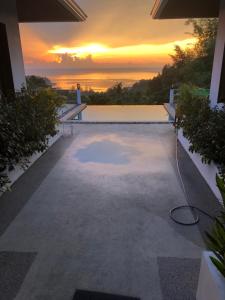 a sunset over a swimming pool in a house at Luxurious Pool villa with great sea view in Koh Phangan