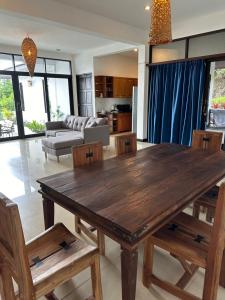 a living room with a wooden table and chairs at Luxurious Pool villa with great sea view in Ko Phangan