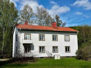 a large white house with a red roof at Vindsvåning Ljungaverk in Ljungaverk