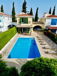une grande maison avec une piscine en face de celle-ci dans l'établissement Villa Lorena Protaras, à Protaras