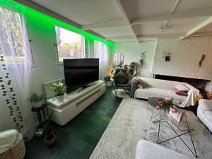 a living room with green lights on the walls at Stenkällevägen 60 in Malmö