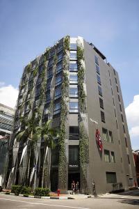 a building with plants growing on the side of it at Naumi Hotel in Singapore
