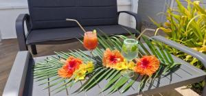 einen Tisch mit Blumen und einen Drink darauf in der Unterkunft La villa Tina in Ducos