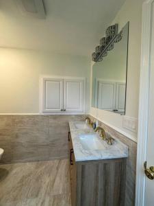 ein Bad mit einem Waschbecken und einem Spiegel in der Unterkunft Home away on Lake Ontario in Youngstown