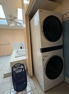 ein Badezimmer mit einer Waschmaschine und einem Trockner neben einem Waschbecken in der Unterkunft Home away on Lake Ontario in Youngstown