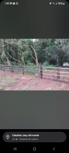 a picture of a fence with a car in a field at cabañas y camping jv in Leandro N. Alem