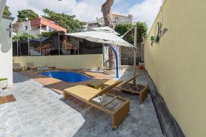 eine Terrasse mit einem Sonnenschirm und einem Pool in der Unterkunft Casa Lola in Tiana