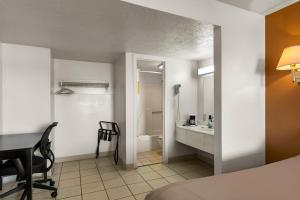 a room with a bed and a bathroom with a sink at Americas Best Value Inn - Lincoln in Lincoln +23 photos