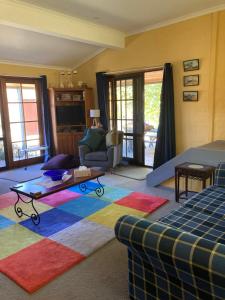 庫馬的住宿－庫馬伍德維爾度假屋，客厅配有沙发和色彩缤纷的地毯