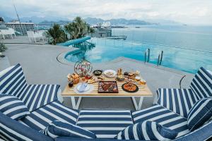 a table with food on it next to a pool at CoolSea Panorama Superview Nha Trang Apartment in Nha Trang