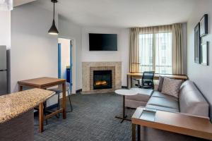 Residence Inn by Marriott Birmingham Downtown UAB في برمنغهام: غرفة معيشة مع أريكة ومدفأة