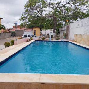 a swimming pool with blue water in a yard at Residencial Jardins Ilha de Itamaracá in Vila Velha