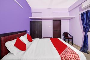 a bedroom with a bed with red and white pillows at OYO Flagship 24 Stays in Chinhat
