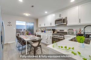 a kitchen with white cabinets and a table with chairs at Entire Private 3-Bedroom Townhouse with King Bed near Bay & Beach, No Deposit in Chula Vista