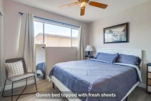 a bedroom with a bed with a blue comforter and a window at Entire Private 3-Bedroom Townhouse with King Bed near Bay & Beach, No Deposit in Chula Vista