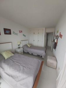 1 dormitorio blanco con 2 camas en una habitación en La mano, en Punta del Este