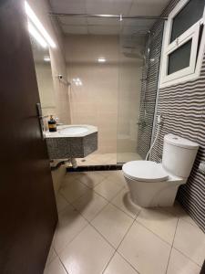 La salle de bains est pourvue de toilettes et d'un lavabo. dans l'établissement 2BHK apt. oasis tower, à Ajman