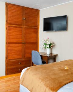 a bedroom with a bed and a desk and a tv at El puente Hotel Boutique in Arequipa