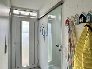 a hallway with a door and a wall with paintings at Ferienhaus DEICHBLICK in Tossenserdeich +20 photos