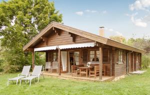 a cabin with a table and chairs in the grass at Ferienhaus Tauber 98 in Hayingen