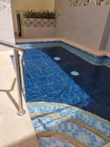 una piscina con azulejos azules en el suelo en Hotel Zamay Centro Historico, en Santa Marta