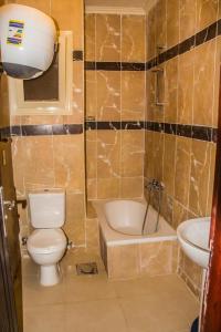 een badkamer met een toilet, een bad en een wastafel bij APARTMENT LASIRENA MINI EGYPT-FAMILY-By Lasirena Group in Ain Sokhna