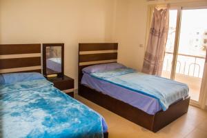 a bedroom with two beds and a window at APARTMENT LASIRENA MINI EGYPT-FAMILY-By Lasirena Group in Ain Sokhna