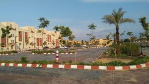 une rue dans une ville avec des bâtiments et des palmiers dans l'établissement APARTMENT LASIRENA MINI EGYPT-FAMILY-By Lasirena Group, à Ain Sokhna