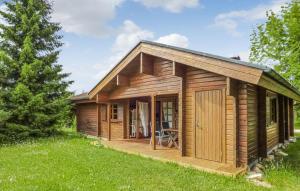 une cabane en bois avec une terrasse couverte dans un champ dans l'établissement Ferienhaus Neckar 45, à Hayingen