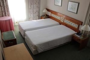 Hotel Universal في جيريز: غرفة فندقية بسريرين وطاولة