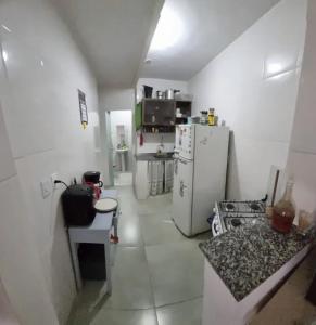 a small kitchen with a refrigerator and a counter at Quarto para Casal in Rio de Janeiro