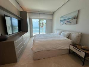 a bedroom with a large bed and a television at Paraíso Frente al Mar en Playa Escondida in María Chiquita