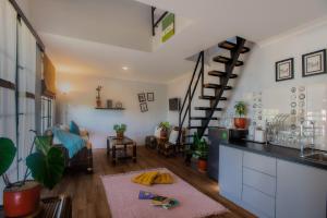 a kitchen and living room with a spiral staircase at Tzy-No Family Cottage in Balong